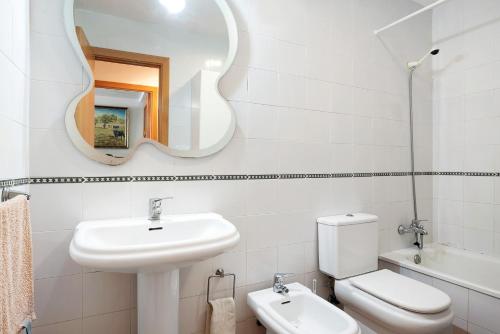 a bathroom with a sink and a toilet and a mirror at Mirador del Palmar in Conil de la Frontera