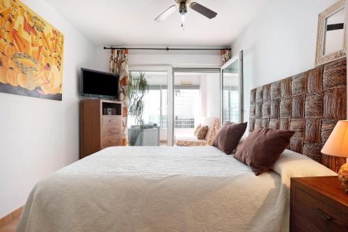 a bedroom with a large bed and a television at Mirador del Palmar in Conil de la Frontera