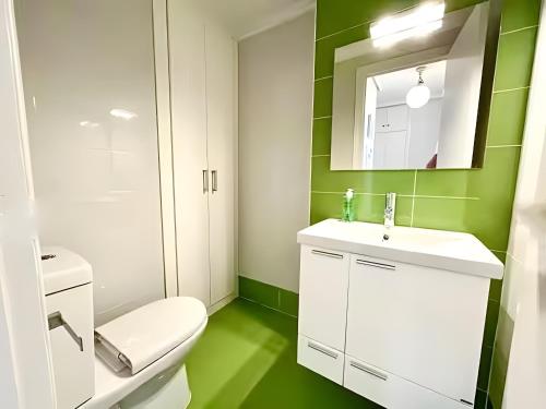 a bathroom with a toilet and a sink and a mirror at Nereidas Beachfront in Cullera