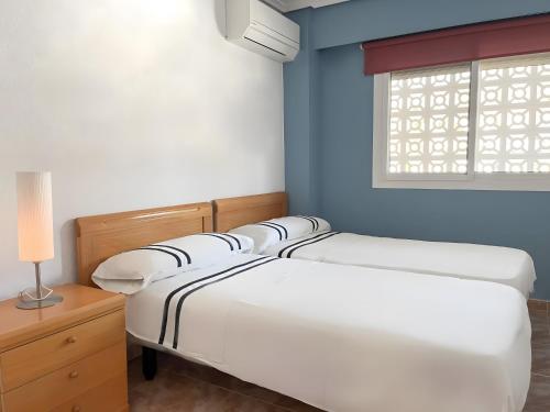 two beds in a room with a window at Nereidas Beachfront in Cullera