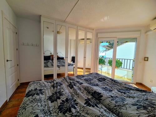 a bedroom with a bed with a view of the ocean at Beach panorama Caleta in Caleta De Velez