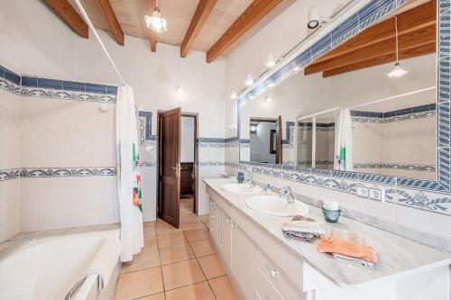 a bathroom with two sinks and a bathtub and a tubermott at Ca S'hereu in Felanitx