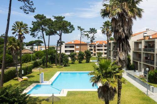 an apartment with a swimming pool and palm trees at Fão Apart Vacation Apartments in Fão
