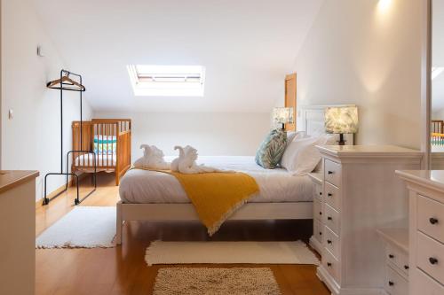 ein Schlafzimmer mit einem Bett, auf dem zwei Stofftiere liegen in der Unterkunft Fão Apart Vacation Apartments in Fão