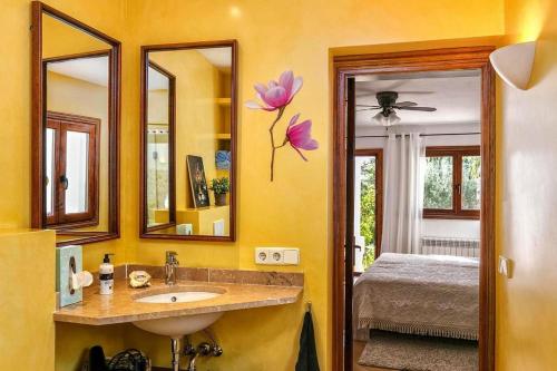 a bathroom with a sink and a mirror and a bed at Casa Maria Angela in Artá