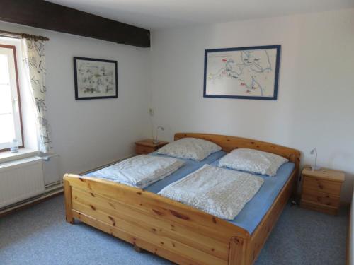 a bedroom with a wooden bed with two pillows at Ferienwohnung Hoffarth 1 in Gelting