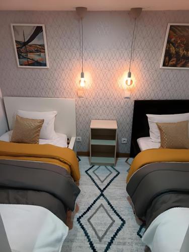 a bedroom with two beds and a table and lights at D'ouro Prestige Relax in Sanfins do Douro