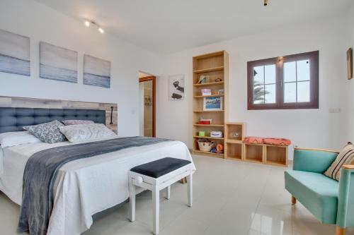 a bedroom with a bed and a blue chair at Villa Kodotoma in Yaiza