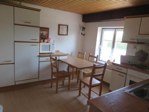 a kitchen with a table with chairs and a microwave at Ferienwohnung Hoffarth 1 in Gelting