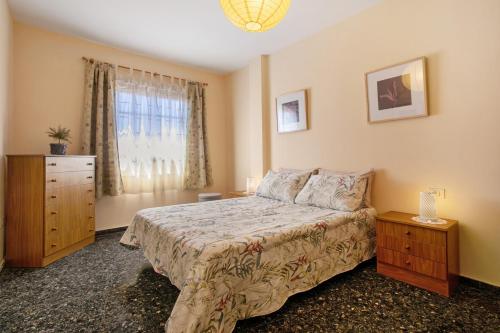 a bedroom with a bed and a dresser and a window at Casa Fefa in Candelaria