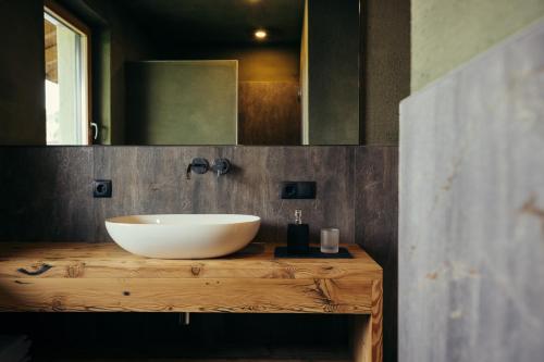 a bathroom with a white bowl sink on a wooden counter at Obertimpflerhof Wohnung Rosi in Verano