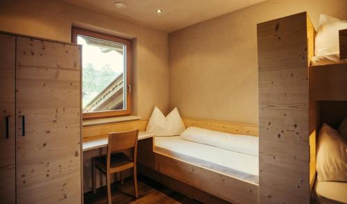 a small room with a bed and a window at Obertimpflerhof Wohnung Rosi in Verano