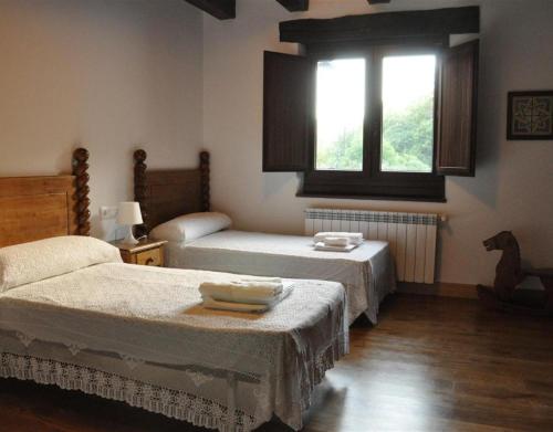 a bedroom with two beds and a window at Barbenea in Oronoz-Mugaire