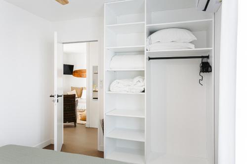 a white closet with white shelves in a room at Les iles, Rivedoux Beach House in Rivedoux-Plage