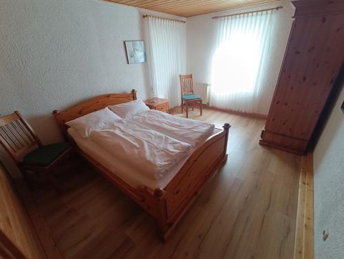 a bedroom with a wooden bed and a window at Ferienwohnung Haarkotten in Steinfurt