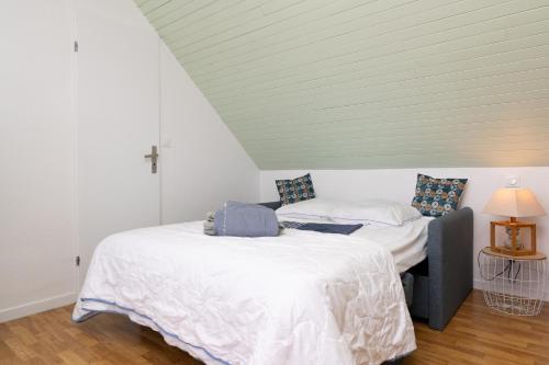 two beds in a room with a white ceiling at Le Sea Bird parking piscine été in Arzon