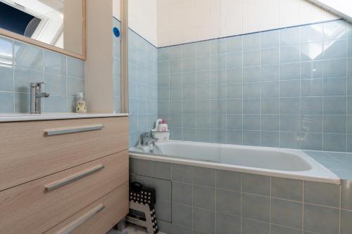 a bathroom with a tub and a sink at Le Sea Bird parking piscine été in Arzon