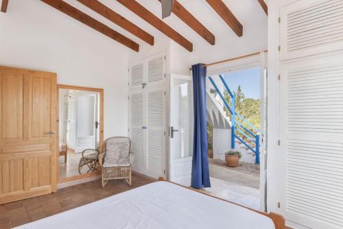 a bedroom with a bed and a sliding glass door at Ses Roques Casa del Sol in Illes Balears