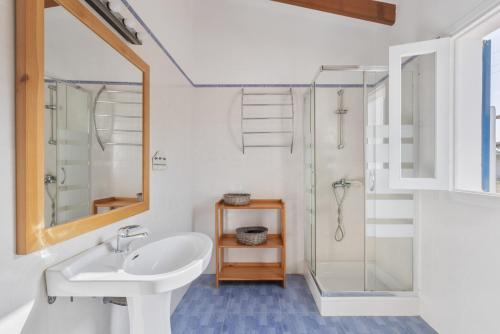 a white bathroom with a sink and a shower at Ses Roques Casa del Sol in Illes Balears