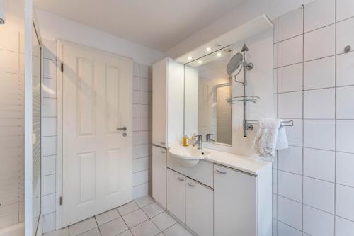 a white bathroom with a sink and a mirror at Ferienwohnung am Rande Neumünsters in Neumünster