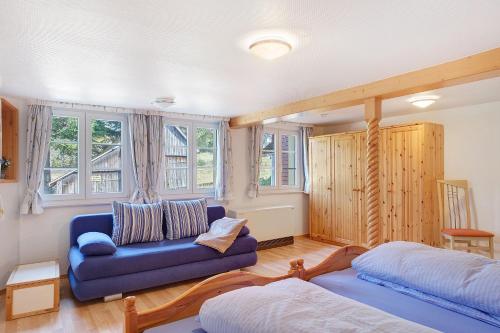 a living room with a blue couch and a bed at Alte Schmiede in Feldberg