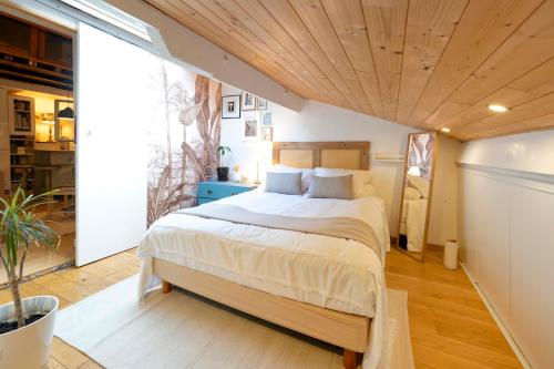 a bedroom with a large bed with a wooden ceiling at Une escale sur l'océan in Ciboure
