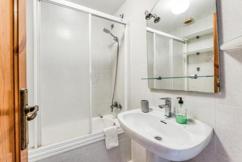 a white bathroom with a sink and a shower at Green Park B18 in Son Parc