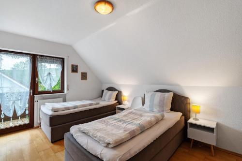 two beds in a room with a window at Ferienwohnung Serr in Lauf
