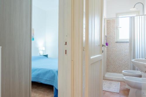 a white bathroom with a bed and a sink at Appartamento Cerri in Badesi