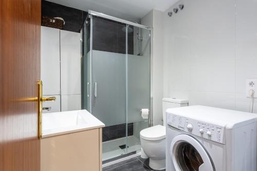 a bathroom with a toilet and a washing machine at Can Maryel in Tossa de Mar