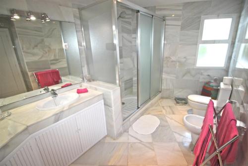 a bathroom with a shower and a sink and a toilet at Deluxe Apartment on the Beach in Marbella