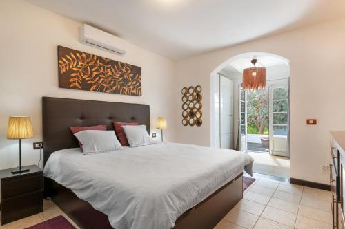 a bedroom with a large bed with white sheets at Villa Calima Deluxe con Piscina in Tías