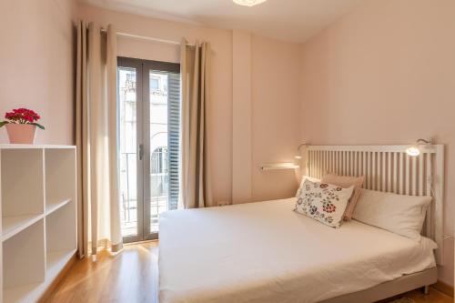 a bedroom with a white bed with a window at Freedom Penthouse in Seville