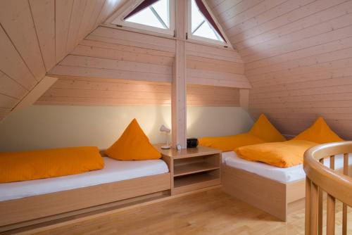 two beds in a attic room with a window at Riehle Hof in Zell am Harmersbach