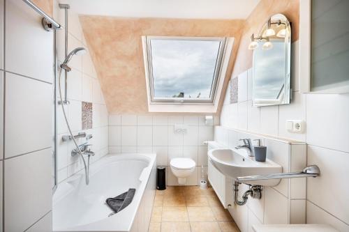 a bathroom with a tub and a sink and a toilet at Ferienwohnung Meeresbrise in Grömitz
