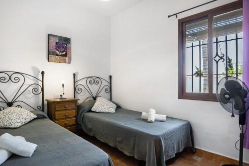 a bedroom with two twin beds and a window at Casa Ale in Cádiz