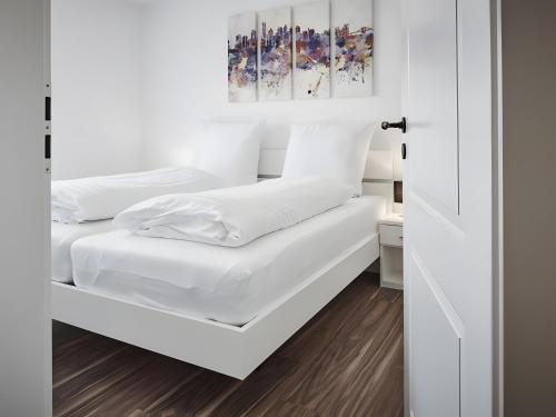 a bedroom with white walls and white bedding at Ferienhaus Elsa 180 qm in Rust