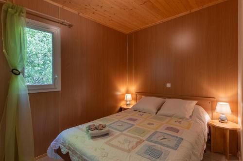 a bedroom with a bed with two lamps and a window at Maison Jordan - Mas Lachamp in Gravières