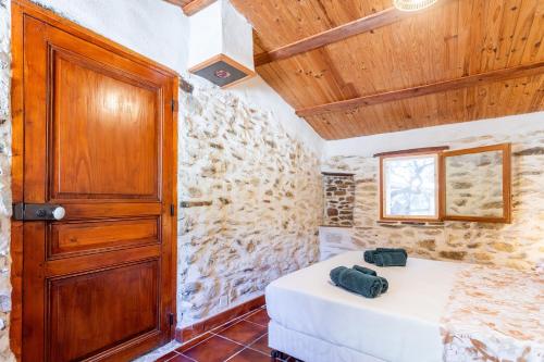 a room with a bed and a wooden door at La Fenière - Maison avec terrasse in Collobrières