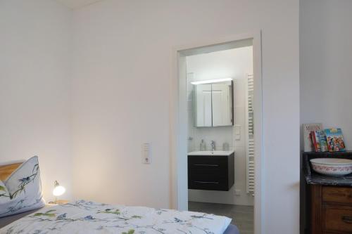 a bedroom with a bed and a sink and a mirror at Sand 68 in Steinau an der Straße