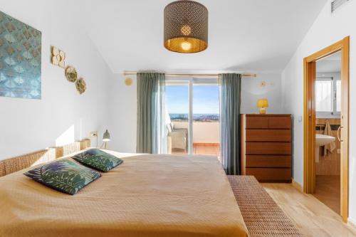 a bedroom with a bed with a view of the ocean at Vistolmar Tivoli A213 in Benalmádena