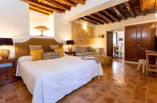a bedroom with a large bed and a living room at Can Pep Den Sitges in Sant Joan de Labritja