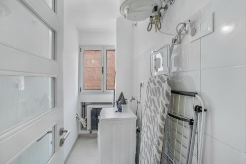 a white bathroom with a sink and a mirror at Vv Brisamar in Telde