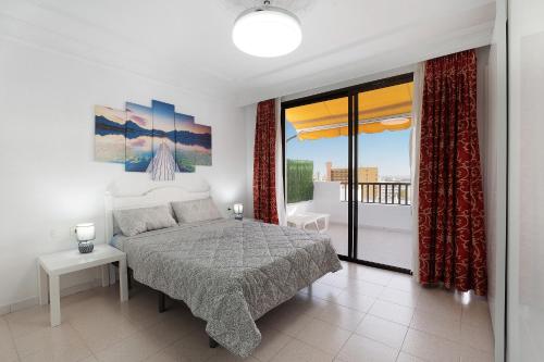 a bedroom with a bed and a view of a balcony at Penthause Luxe 501 sea View pool in Playa Fañabe