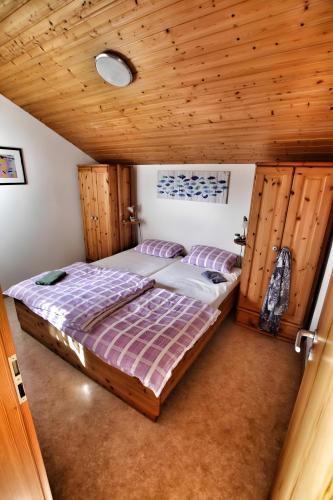 a bedroom with a bed and a wooden ceiling at Ferienhaus Uslar Gmbh Uslar in Uslar
