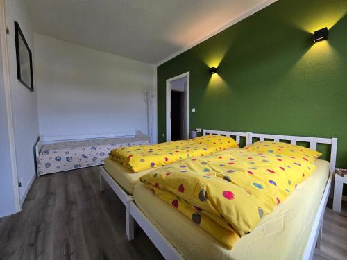 two beds in a room with a green wall at Apartment - Tor zur Rhön in Vachat