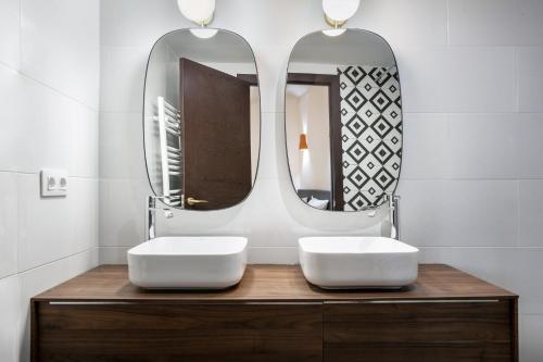 a bathroom with two sinks and two mirrors at Casa Roques 16 in Jávea