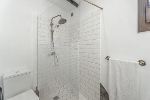 a bathroom with a shower with white tiles at Casa Abuelo Manuel in El Draguito