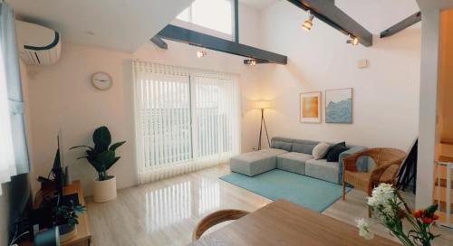 a living room with a couch and a table at Chigasaki Southern Beach House 茅ヶ崎サザンビーチハウス in Chigasaki