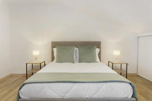 a bedroom with a large bed with two lamps at Sky and Sea Haven in Santa Cruz